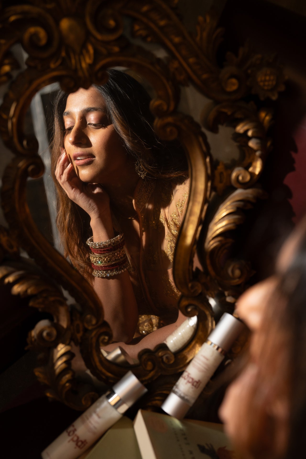 Woman examining her skin in a mirror while checking if her skincare is pregnancy-safe.