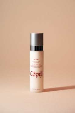 Skincare bottle labeled 'Copdi' on a beige background